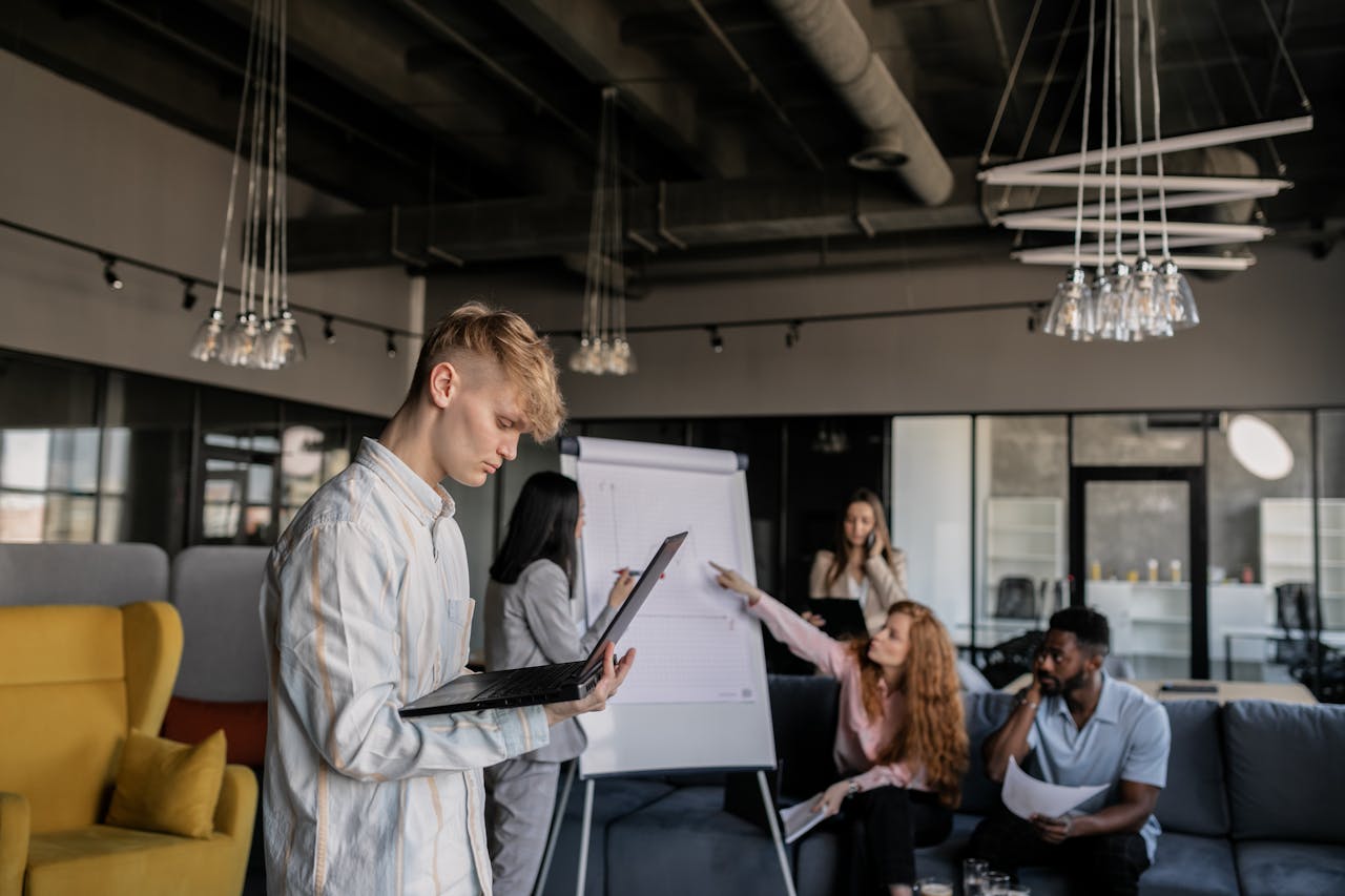 Young professionals collaborating in a modern office space with flip charts and laptops.